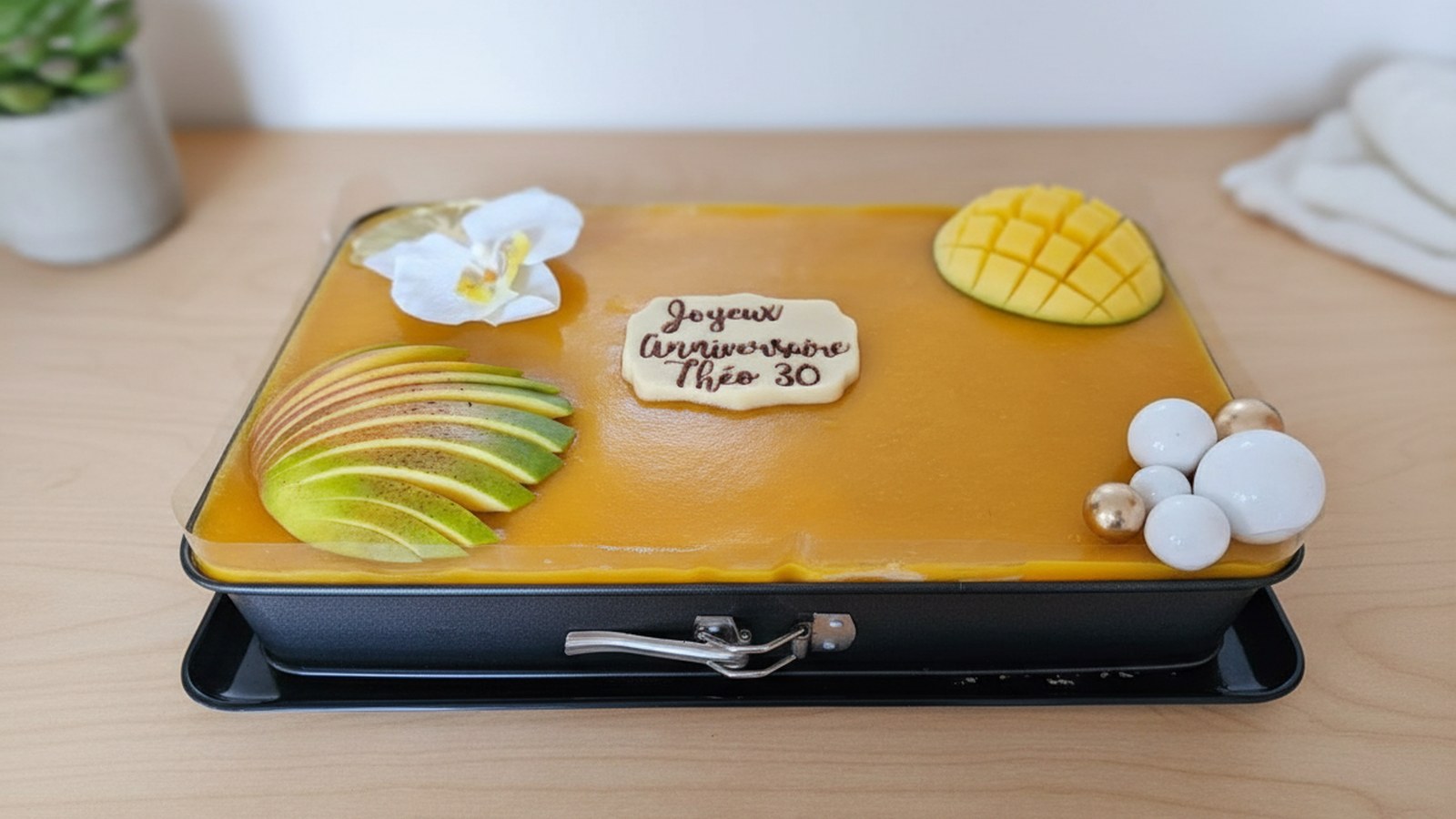 Gâteau anniversaire mangue rectangulaire avec plaque Joyeux Anniversaire Théo 30, orchidée et décoration dorée